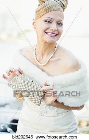 Stock Photograph - Smiling Hispanic bride holding purse. Fotosearch