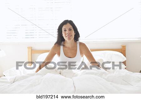 Smiling Hispanic woman sitting in bed View Large Photo Image Picture - Smiling Hispanic woman sitting in bed. Fotosearch