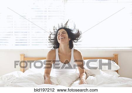 Smiling Hispanic woman sitting in bed View Large Photo Image Stock Image - Smiling Hispanic woman sitting in bed. Fotosearch