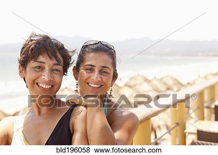 Smiling Hispanic woman standing together on balcony View Large Photo Image Stock Photo - Smiling Hispanic woman standing together on balcony. Fotosearch