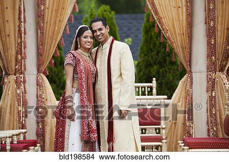 Picture - Smiling Indian couple in traditional wedding clothing. Fotosearch