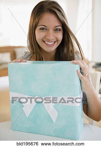 Smiling Indian woman holding birthday gift View Large Photo Image Stock Photograph - Smiling Indian woman holding birthday gift. Fotosearch