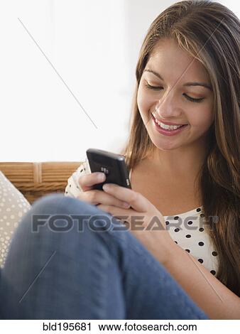 Smiling Indian woman text messaging on cell phone View Large Photo Image Stock Image - Smiling Indian woman text messaging on cell phone. Fotosearch