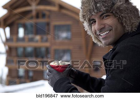 Smiling man drinking hot chocolate outdoors View Large Photo Image Stock Photo - Smiling man drinking hot chocolate outdoors. Fotosearch