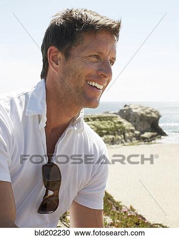 Smiling man enjoying beach View Large Photo Image Stock Image - Smiling man enjoying beach. Fotosearch