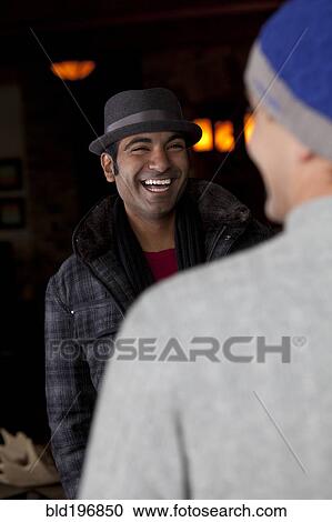 Stock Image - Smiling man socializing with friend. Fotosearch