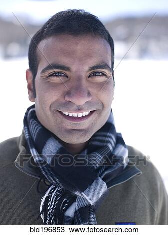 Stock Image - Smiling man standing in snow. Fotosearch