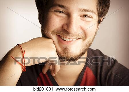 Stock Image - Smiling man with hand on chin. Fotosearch