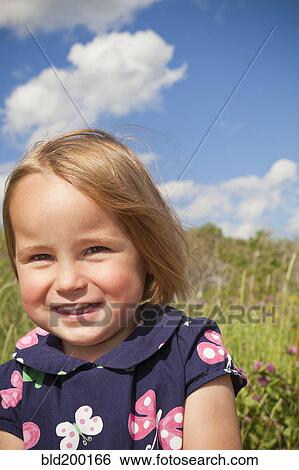 Stock Photograph - Smiling mixed race girl standing outdoors. Fotosearch