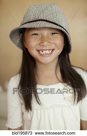 Stock Image - Smiling mixed race girl wearing hat. Fotosearch