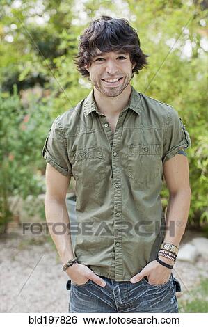 Stock Photograph - Smiling mixed race man with hands in pockets. Fotosearch