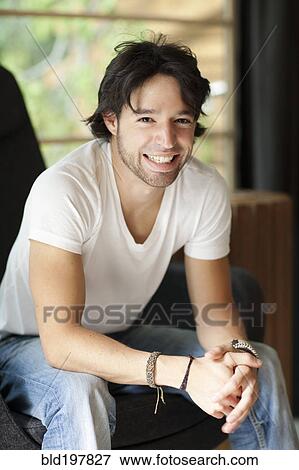 Stock Photo - Smiling mixed race man with hands clasped. Fotosearch