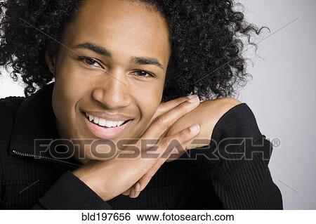 Stock Photograph - Smiling mixed race man with hands clasped. Fotosearch