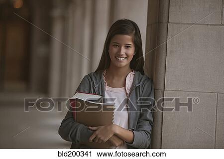 Stock Image - Smiling mixed race student on campus. Fotosearch
