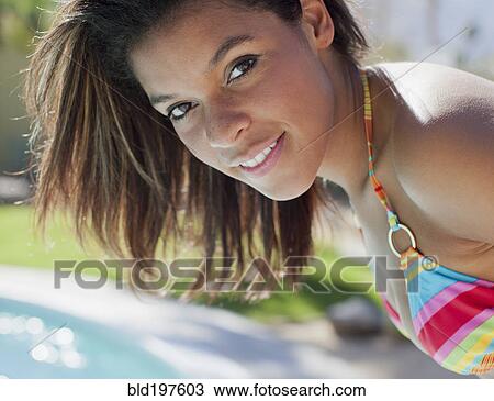 Stock Image - Smiling mixed race woman in bikini. Fotosearch