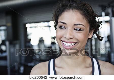 Stock Image - Smiling mixed race woman in health club. Fotosearch