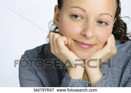 Stock Photo - Smiling mixed race woman with head in hands. Fotosearch