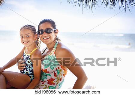 Stock Photograph - Smiling mother and daughter enjoying tropical beach. Fotosearch