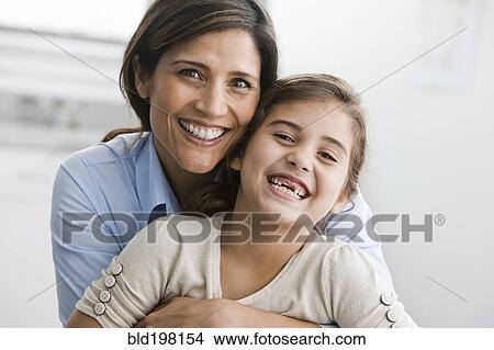 Picture - Smiling mother and daughter hugging. Fotosearch