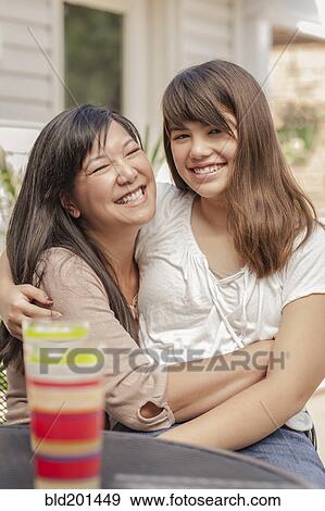 Smiling mother and daughter hugging View Large Photo Image Stock Photo - Smiling mother and daughter hugging. Fotosearch