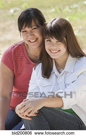 Stock Photograph - Smiling mother and daughter outdoors. Fotosearch