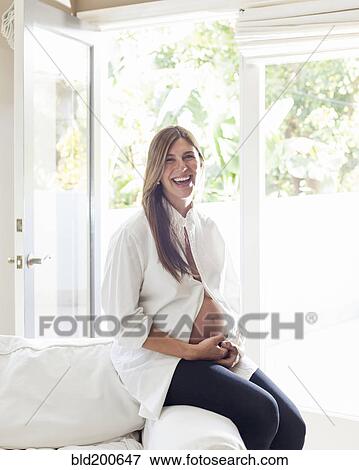 Stock Photo - Smiling pregnant Hispanic woman. Fotosearch