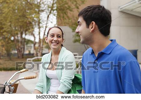 Stock Image - Smiling students talking on campus. Fotosearch