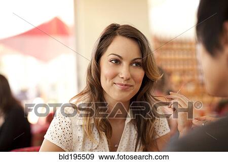 Stock Photo - Smiling woman and man sitting face to face. Fotosearch