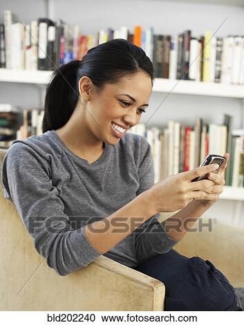 Smiling woman text messaging on cell phone View Large Photo Image Stock Image - Smiling woman text messaging on cell phone. Fotosearch