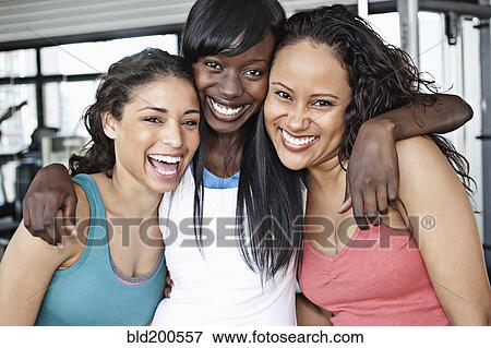 Stock Photo - Smiling women hugging in health club. Fotosearch