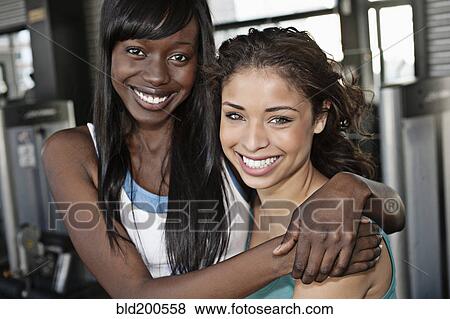 Stock Photo - Smiling women hugging in health club. Fotosearch