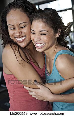 Stock Photo - Smiling women hugging in health club. Fotosearch