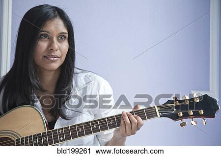 Stock Image - Sri Lankan woman playing guitar. Fotosearch