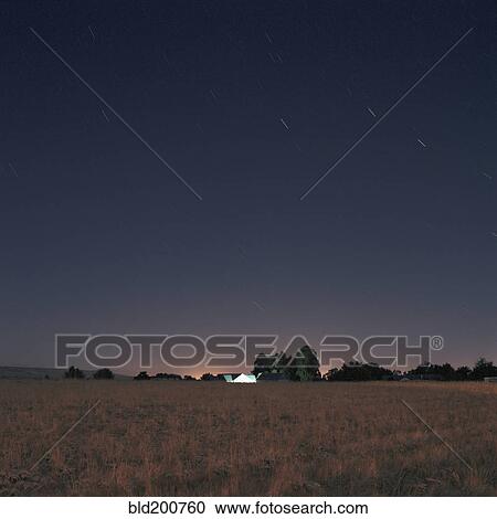 Stock Image - Stars and sunset over field. Fotosearch