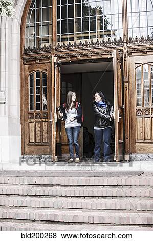 Stock Photo - Students coming out of college doorway. Fotosearch