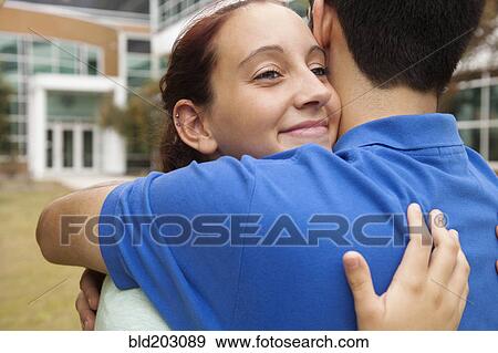 Stock Photo - Students hugging on campus. Fotosearch