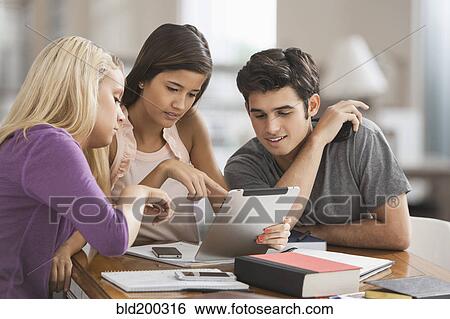 Stock Photograph - Students looking at digital tablet. Fotosearch