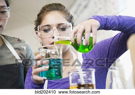 Stock Image - Students working with chemicals in classroom. Fotosearch
