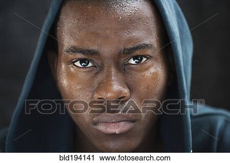 Stock Image - Sweating mixed race man in hoody. Fotosearch