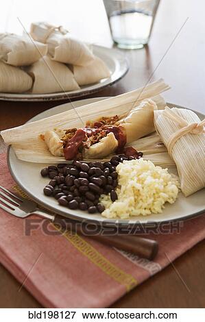 Tamales, beans and rice on plate View Large Photo Image Stock Photo - Tamales, beans and rice on plate. Fotosearch
