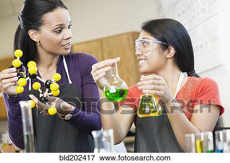 Stock Photo - Teacher and student working with chemicals in classroom. Fotosearch