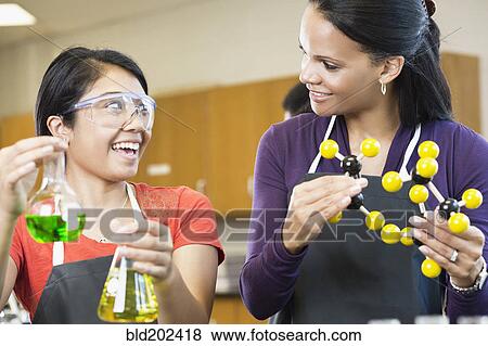 Stock Photo - Teacher and student working with chemicals in classroom. Fotosearch