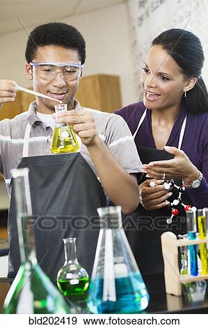 Stock Photo - Teacher and student working with chemicals in classroom. Fotosearch
