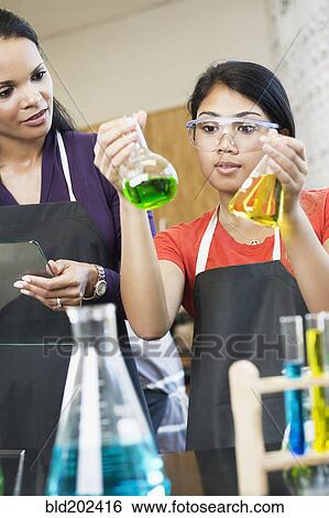 Stock Photograph - Teacher and student working with chemicals in classroom. Fotosearch
