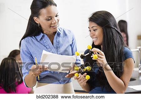 Stock Photo - Teacher explaining chemistry model to student. Fotosearch