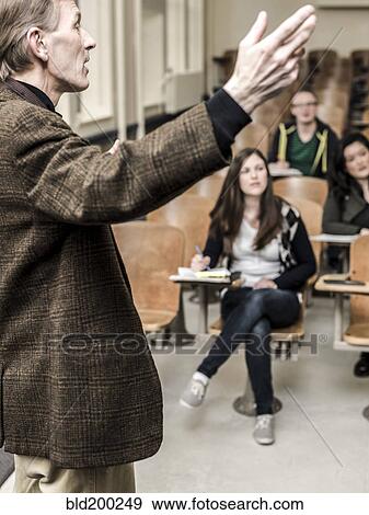 Stock Photo - Teacher talking to students in classroom. Fotosearch