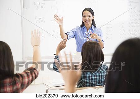 Stock Photo - Teacher talking to students in classroom. Fotosearch