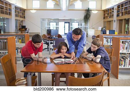Teacher talking to students in library View Large Photo Image Stock Photograph - Teacher talking to students in library. Fotosearch