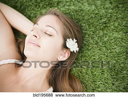 Stock Photo - Tranquil Indian woman sleeping in grass. Fotosearch