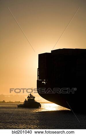 Stock Image - Tugboat and container ship in port of Oakland. Fotosearch